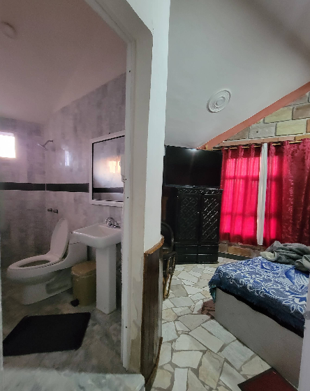 Baño y cama vistos desde la puerta